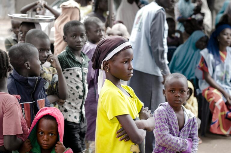 A group of children gathered together outdoors in Abuja, Nigeria, showcasing diversity and community.