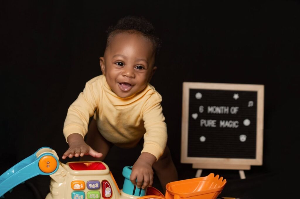 Joyful baby boy playing with colorful toys in a studio setting.