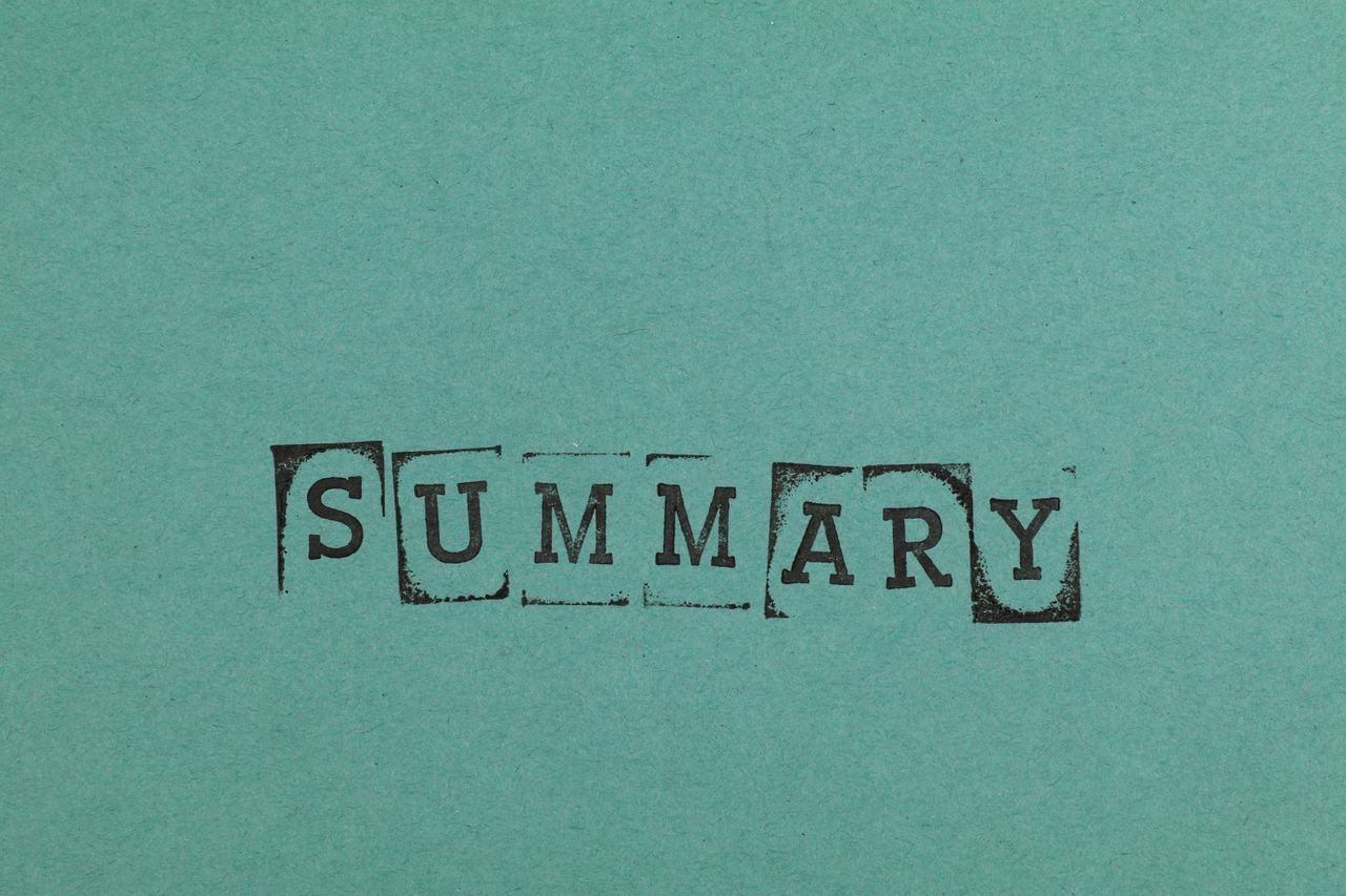 Close-up of the word 'SUMMARY' stamped on a green paper surface, offering ample copy space.